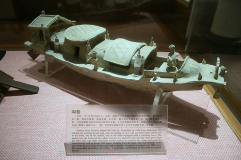 
An Eastern Han (25–220 AD) Chinese pottery boat fit for riverine and maritime sea travel, with an anchor at the bow, a steering rudder at the stern, roofed compartments with windows and doors, and miniature sailors.